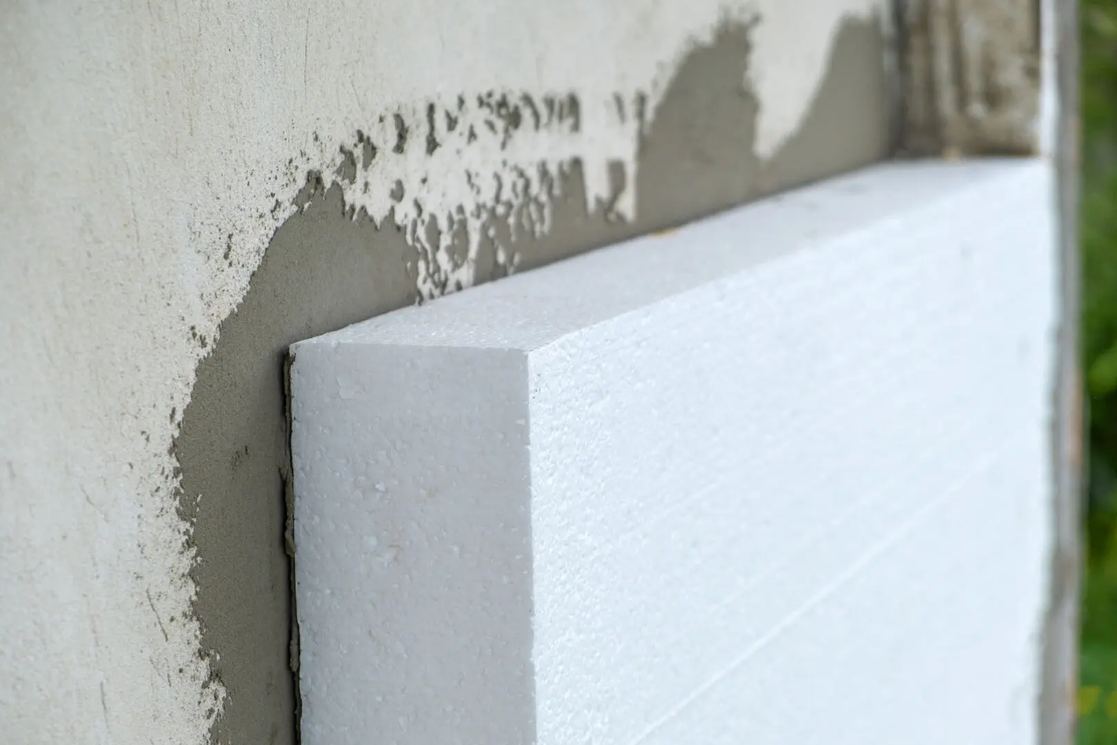 Installation of styrofoam insulation panel on facade